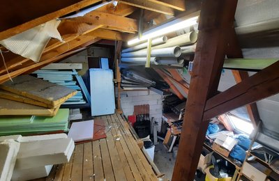 Dachbodenräumung Hessen, vollgestellter Dachboden mit Baumaterialien und Rohren