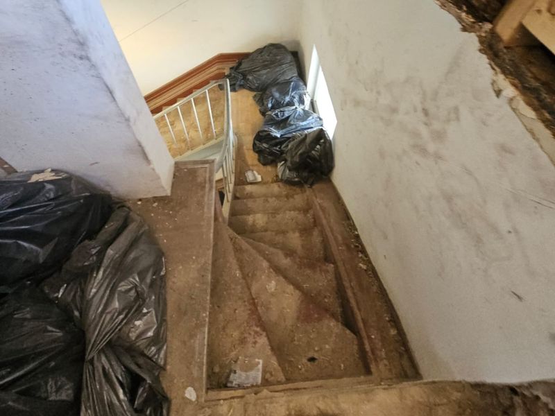 Dachbodenräumung in Wiesbaden: Schuttsäcke an der engen Wendeltreppe eines Altbaus