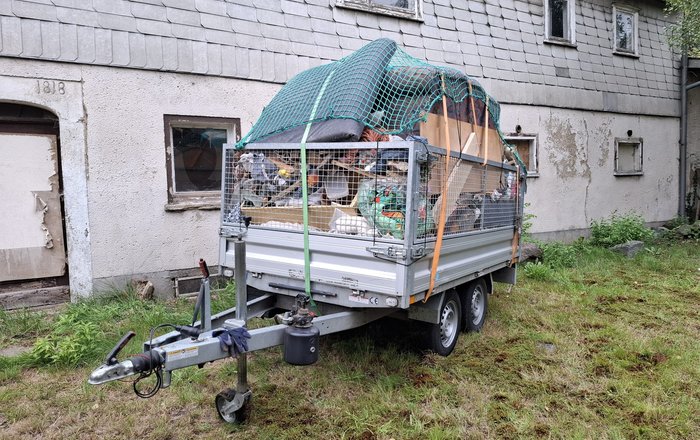 Sperrmüll Entsorgung Hessen, vollbeladener Anhänger mit Gerümpel und Sperrmüll wird fachgerecht abtransportiert