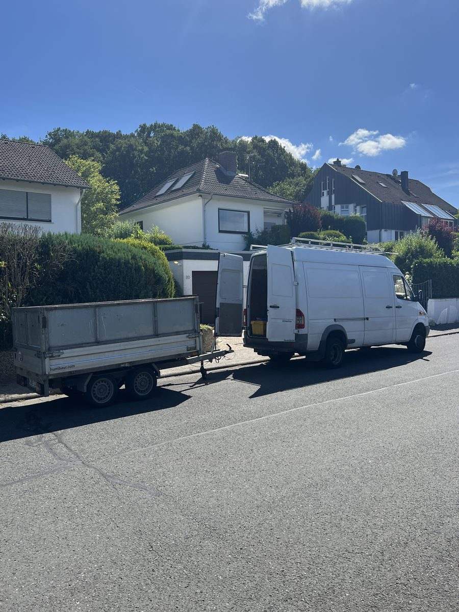 Transporter mit Anhänger von Entrümpelung Hessen vor einem Wohnhaus im Rhein-Main-Gebiet, bereit für eine Räumung