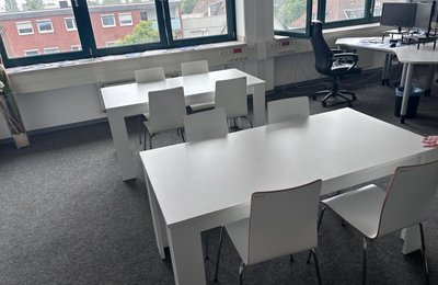 Gewerbliche Entrümpelung Hessen, Besprechungsraum mit weißen Tischen und Stühlen bei Büroauflösung in Hessen