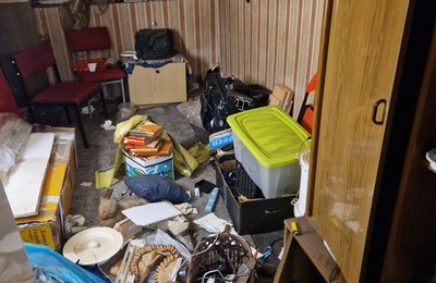 Messiewohnung Hessen, vollgestelltes Zimmer mit Tapete und Unmengen an Gegenständen