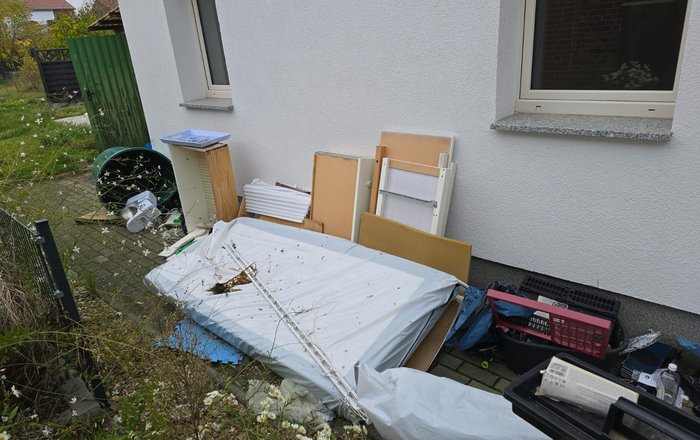 Sperrmüll Abholung Hessen, großer Sperrmüllhaufen mit Möbeln, Matratzen und Gerümpel vor Hauseingang wird abgeholt