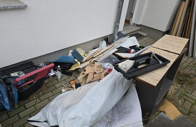 Sperrmüll Hessen, gemischtes Gerümpel mit Kartonage, Plastikteilen und alten Möbeln vor Hauseingang