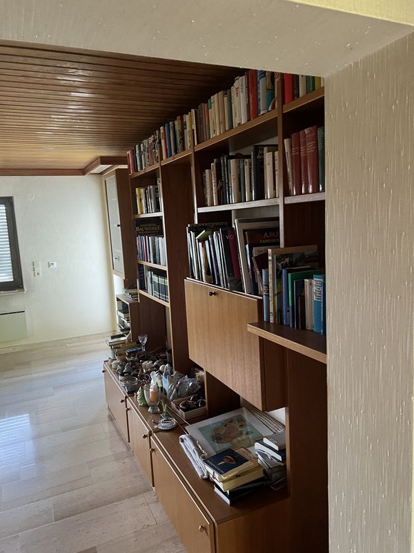 Vorher: Wohnraum mit voller Bücherwand vor der Haushaltsauflösung in Hochheim